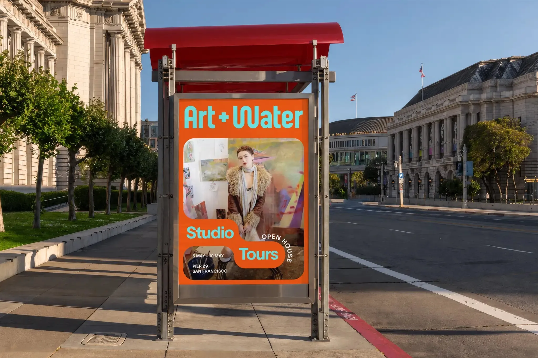 Parada de autobús con un cartel naranja y turquesa de «Art + Water Studio Tours», con una foto en un marco redondeado