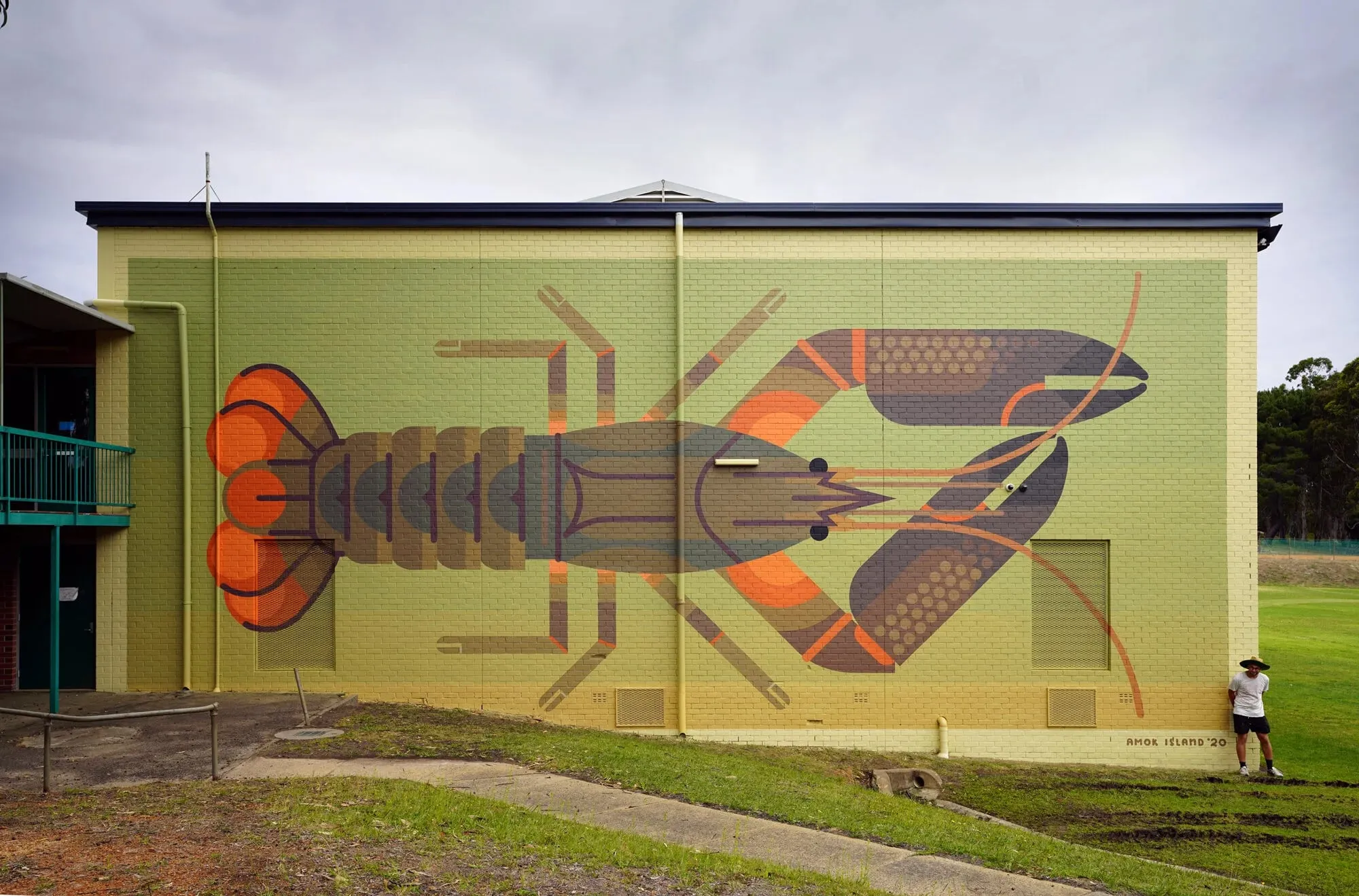 Muro verde con una langosta de río geométrica de caparazón oscuro y pinzas naranjas