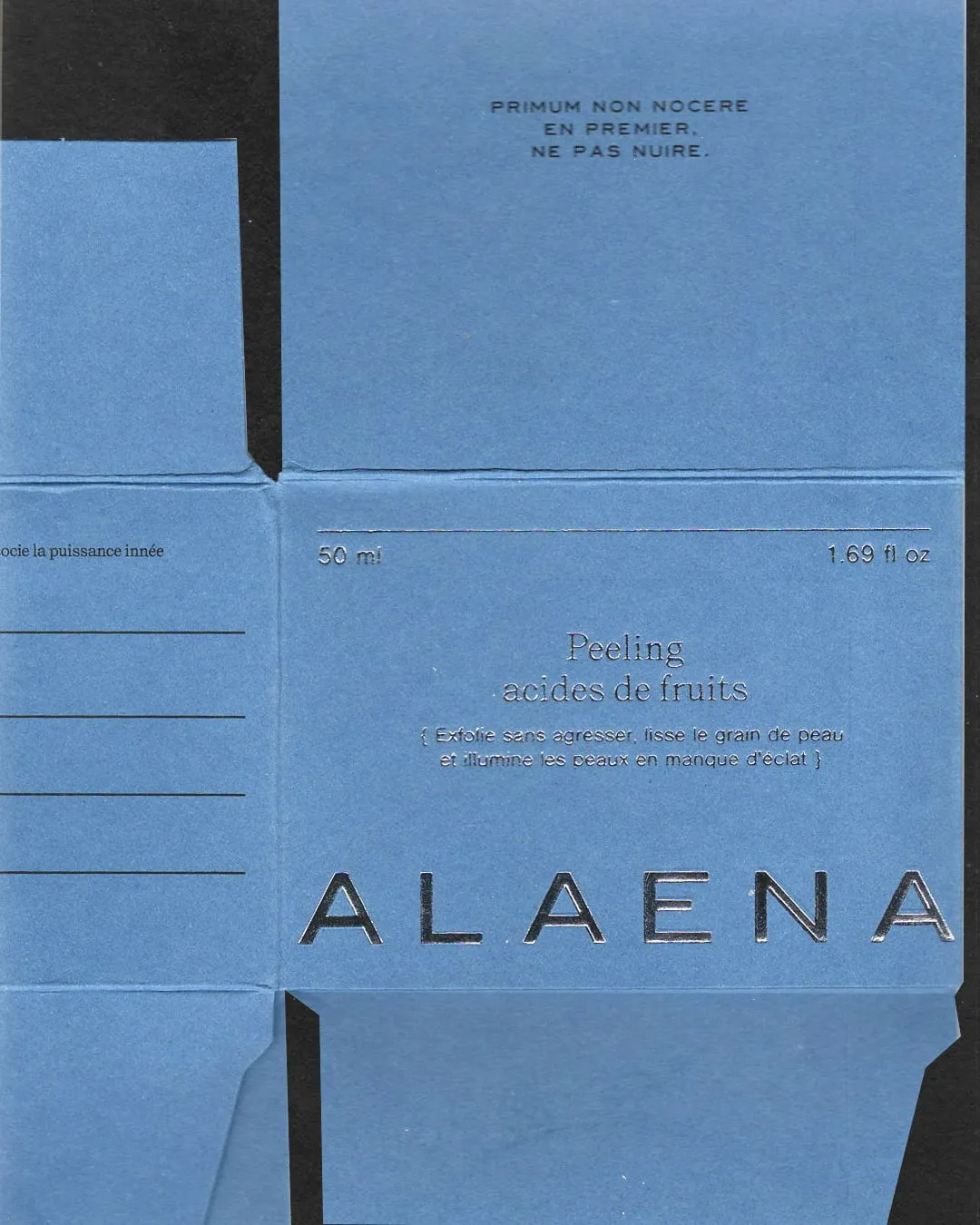 Detalle de una caja de cartón azul de Alaena con el texto en relieve «Primum non nocere, en premier, ne pas nuire»
