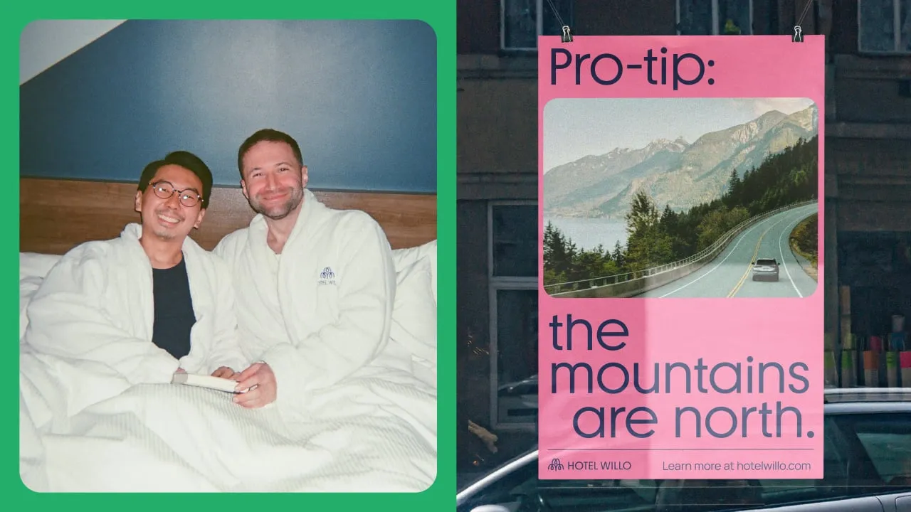 Dos huéspedes sonríen en la cama con albornoces de Hotel Willo, junto a un cartel rosa que señala hacia las montañas al norte de Vancouver