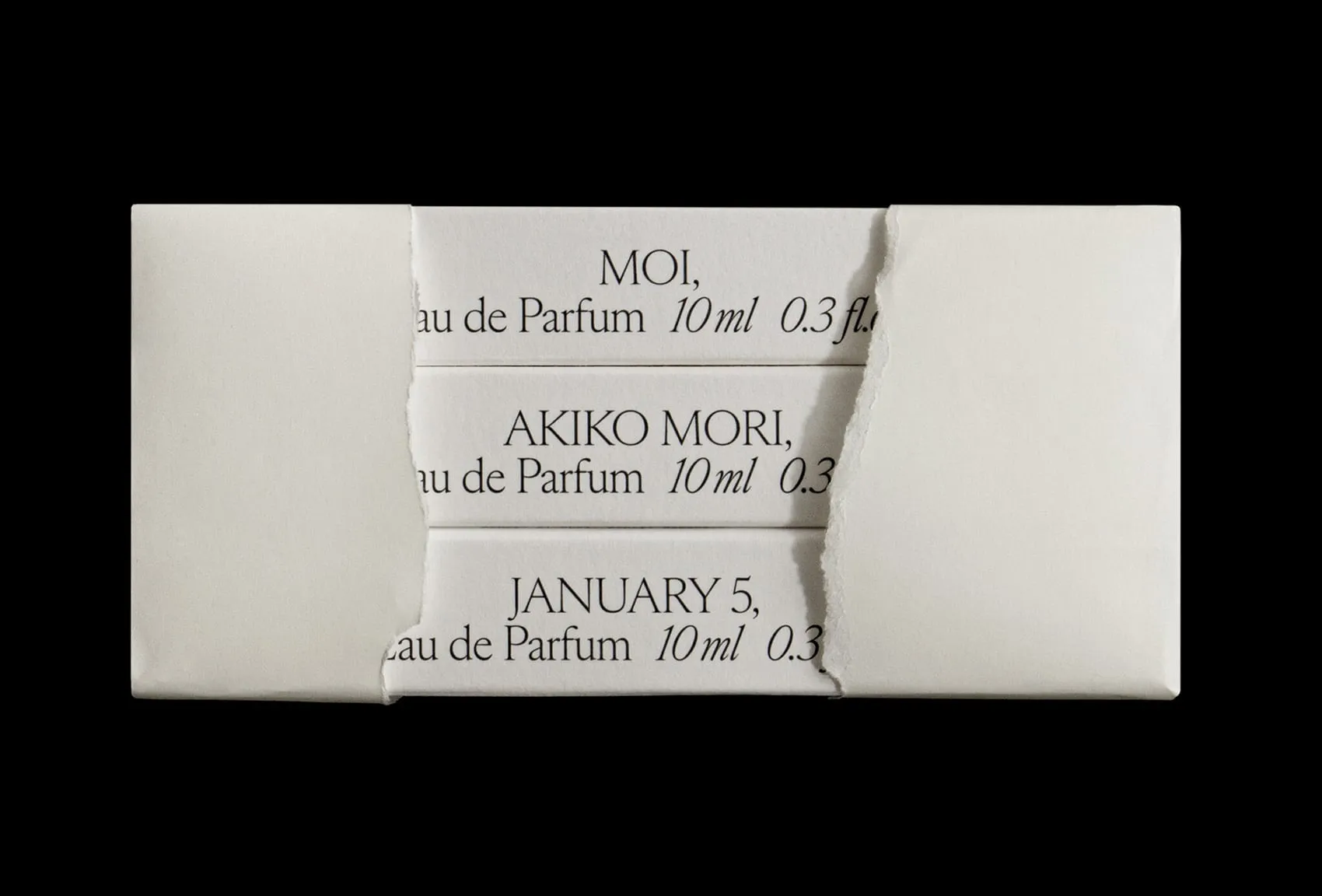 Las tres cajas pequeñas de 10 ml con los nombres de los aromas, asomando por el rasgón de un sobre de papel blanco sobre fondo negro