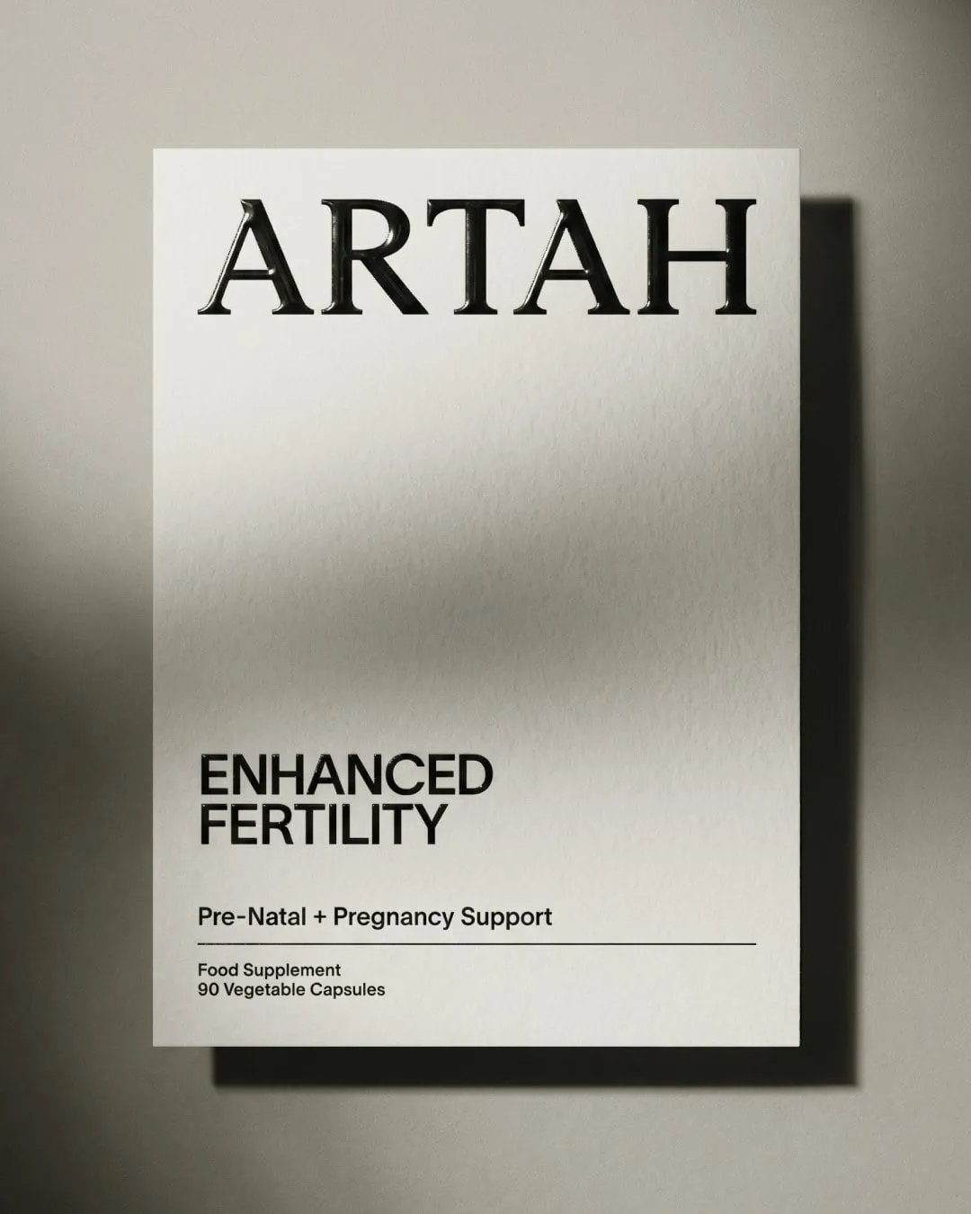 Caja blanca de Artah con el nombre en relieve y la etiqueta «Enhanced Fertility», proyectando una sombra en diagonal
