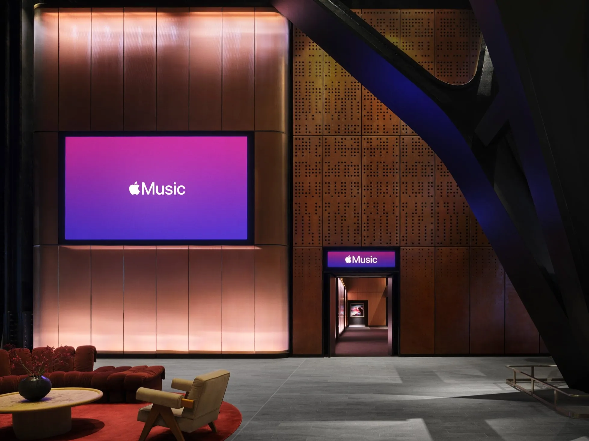 Vestíbulo de Apple Music Hall con una pantalla que muestra el logotipo antiguo de Apple Music, en mayúscula y sobre un fondo degradado de rosa a morado
