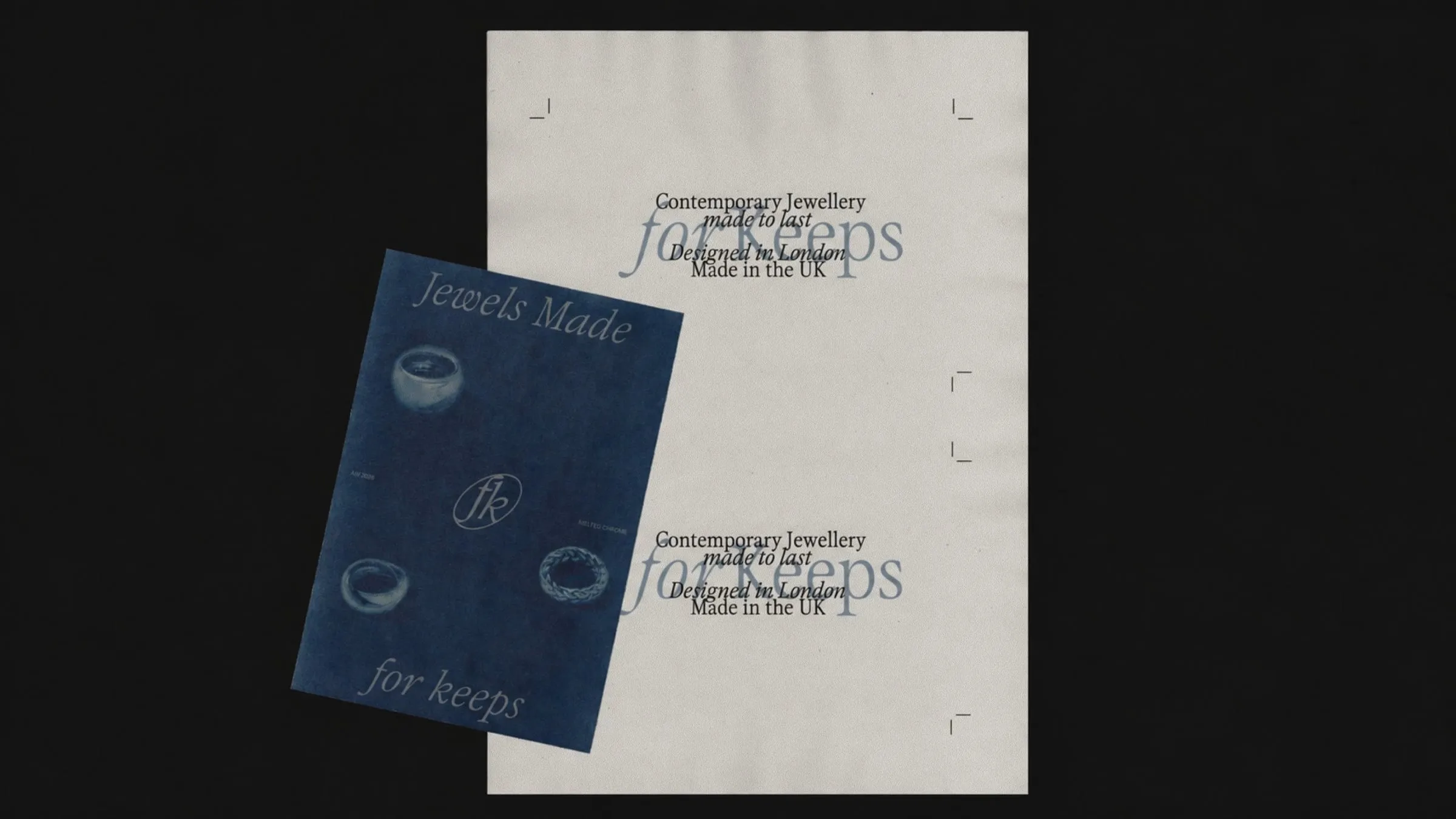 Cartel azul inclinado con anillos sobre una hoja de papel crudo con la frase «Contemporary Jewellery made to last» y el logotipo superpuesto en azul