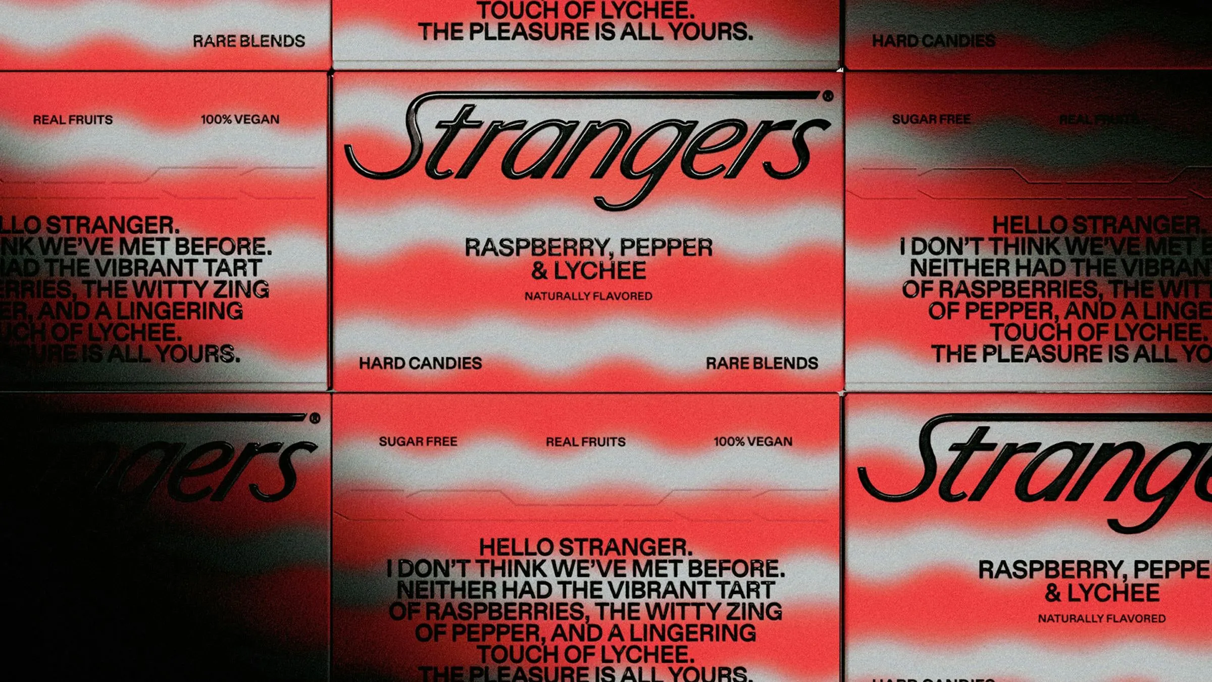 Pared de cajas de caramelos Strangers de frambuesa, pimienta y lichi, con ondas rosas y blancas sobre fondo negro y el logotipo cortado por el encuadre