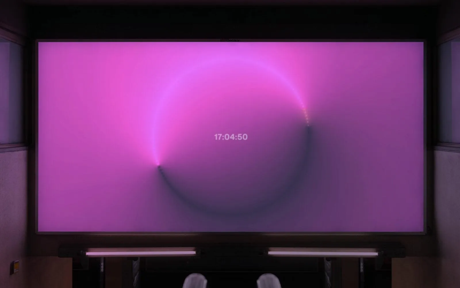 Pantalla con un degradado rosa y morado en forma de círculo y la hora 17:04:50 en el centro