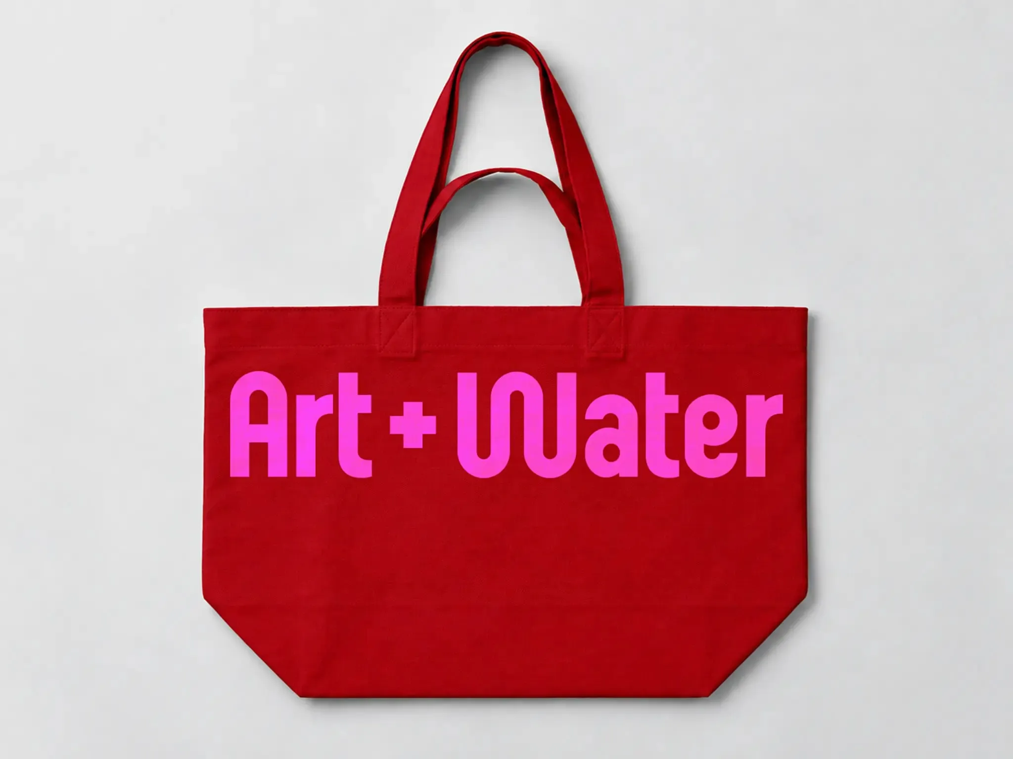 Bolsa de tela roja con asas y el logotipo «Art + Water» en fucsia