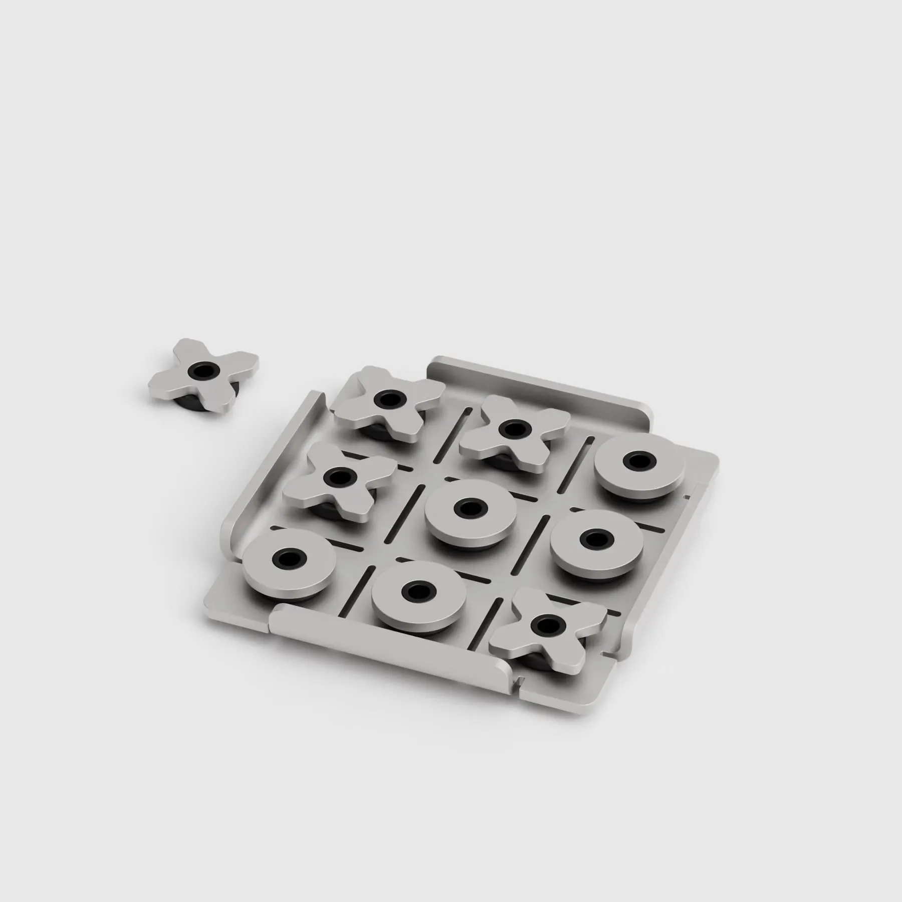 Tablero de aluminio gris con ranuras a modo de líneas, cinco círculos y cuatro cruces colocados y una quinta cruz suelta, sobre fondo claro